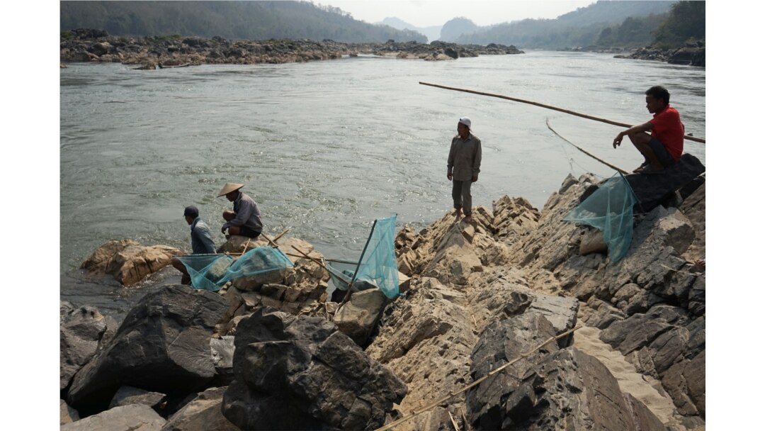 FILE - Fishermen cast their nets on the Mekong River near Luang Prabang, Laos, close to the site of a future dam, Feb. 8, 2020.