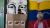 Un hombre emite su voto frente a un mural del fallecido presidente Hugo Chávez como parte de un ensayo para las elecciones presidenciales del 28 de julio en un centro de votación en Caracas, Venezuela, el domingo 30 de junio de 2024. (Foto AP/Cristian Hernandez Fortune)