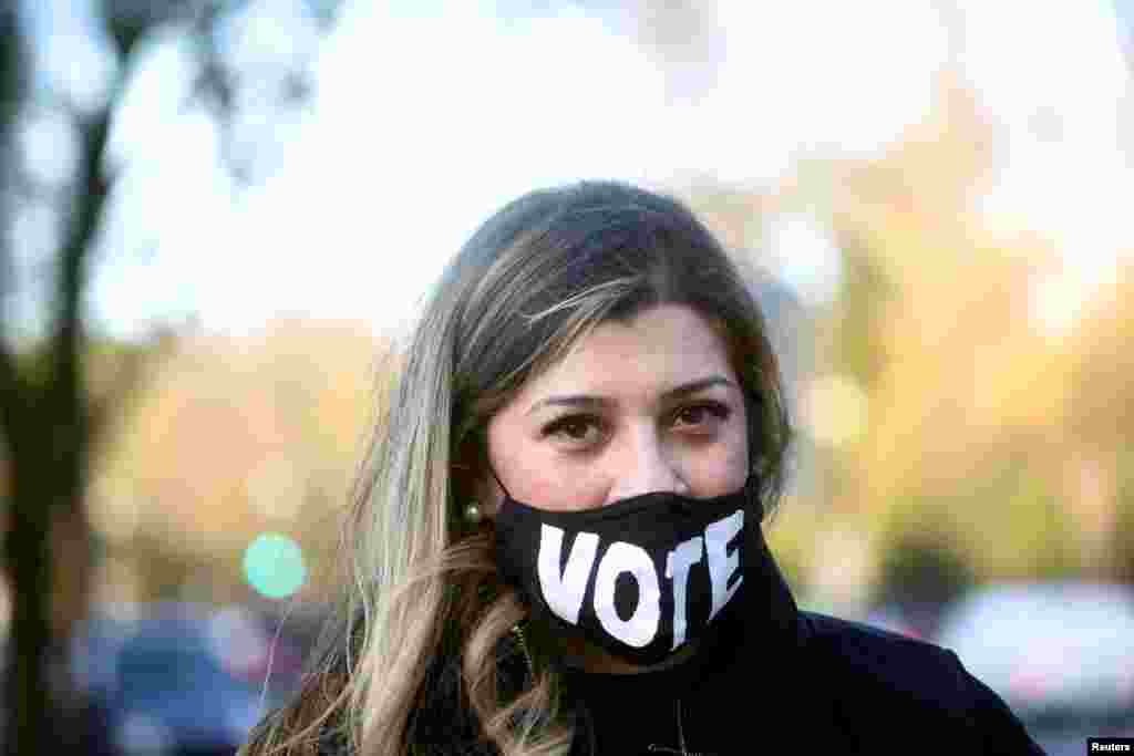 A woman wears a mask with a sign "VOTE" on the day of the 2020 U.S. presidential election in Washington, Nov. 3, 2020.