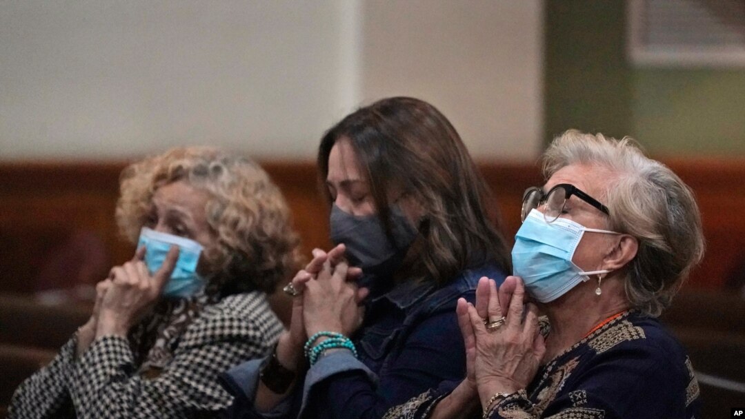 Women pray, June 26, 2021, during a prayer vigil for the victims and families of the Champlain Towers collapsed building in Surfside, Fla., at the nearby St. Joseph Catholic Church in Miami Beach, Fla.