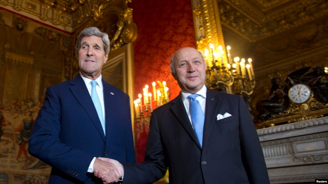 U.S. Secretary of State John Kerry (L) shakes hands with French Foreign Minister Laurent Fabius as he arrives at the Quai d'Orsay in Paris, Oct. 13, 2014.