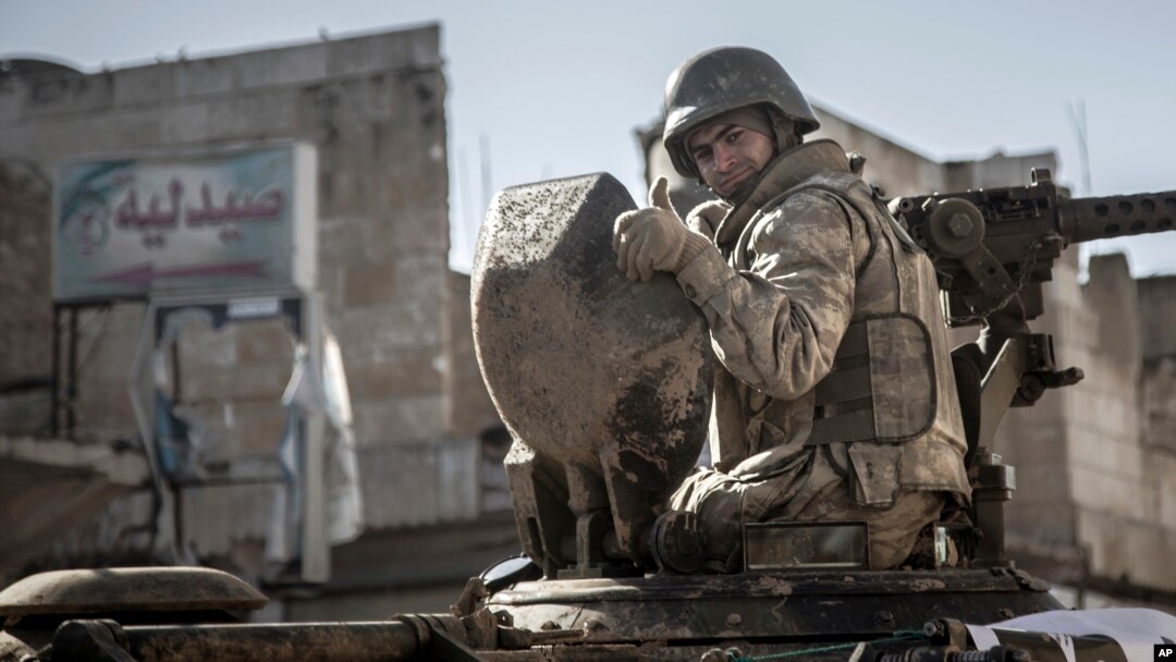 FILE - A soldier gives a thumbs-up sign as Turkish army's armored vehicles and tanks roll into the Syrian town of Ayn al-Arab, Feb. 22, 2015.