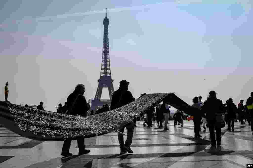 People carry a dark banner bearing the names of missing Colombian people in Paris, France, ahead of a march to the International criminal court (ICC) of the Hague by Colombian citizens in Europe to raise awareness on human rights abuses and the 'systematic assassination of social leaders' in Colombia.