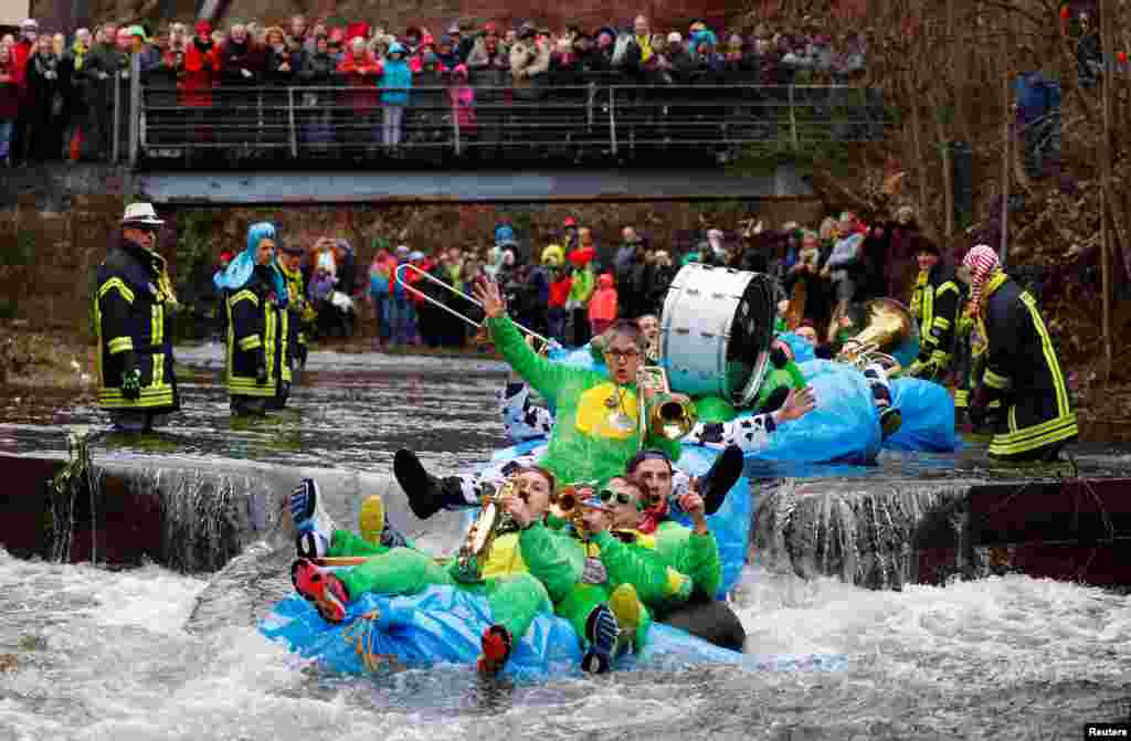 Carnival revelers with their self-made floats ride down the Schiltach stream during the 'Bach na fahre' (race down the stream) raft contest in Schramberg, Germany.