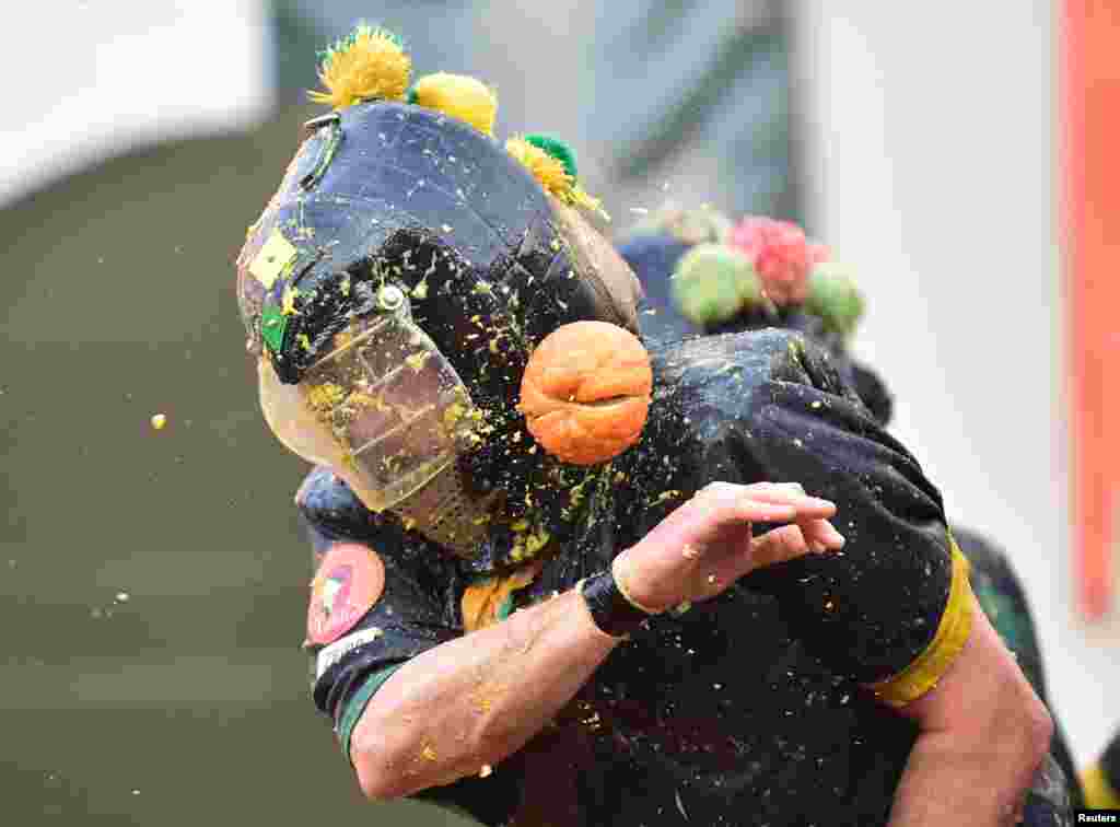 Revelers take part in a fight with oranges during an annual carnival battle in Ivrea, Italy.