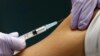 FILE - A medical worker receives a shot at a hospital in Tokyo.