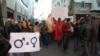 FILE - A woman activist carries a sign promoting gender equality at a rally in Rabat, Morocco.