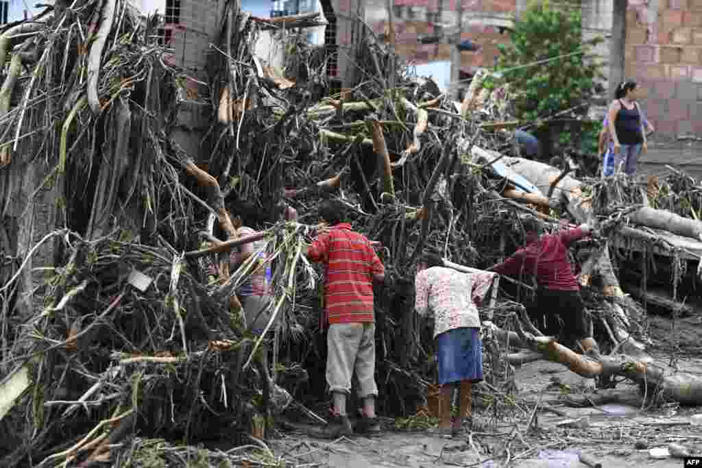 Residents search for their missing relatives in the rubble of a house destroyed by a landslide during heavy rains in Las Tejerias, Aragua state, Venezuela, Oct. 9, 2022. A landslide in central Venezuela left at least 22 people dead and more than 50 missing after heavy rains caused a river to overflow, Vice President Delcy Rodriguez said. 