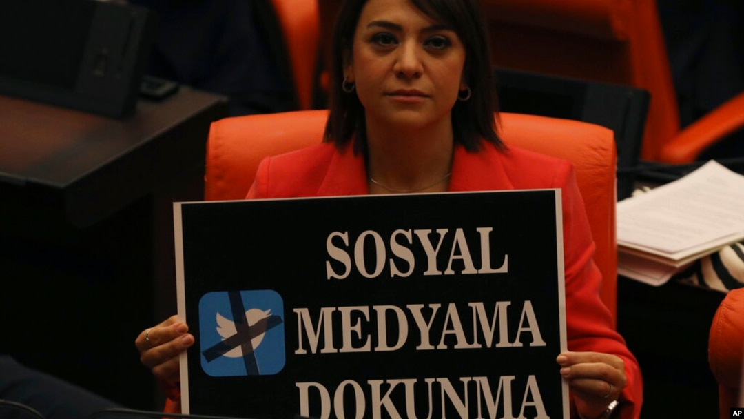 FILE - A lawmaker from the main opposition Republican People's Party holds up a placard that reads "Don't touch my social media" in protest at the parliament, in Ankara, Turkey, Oct. 11, 2022.