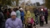 People wait in line as humanitarian aid is distributed at the village of Mykhailo Lukasheve, in Zaporizhzhia region, Ukraine, Oct. 20, 2022. 