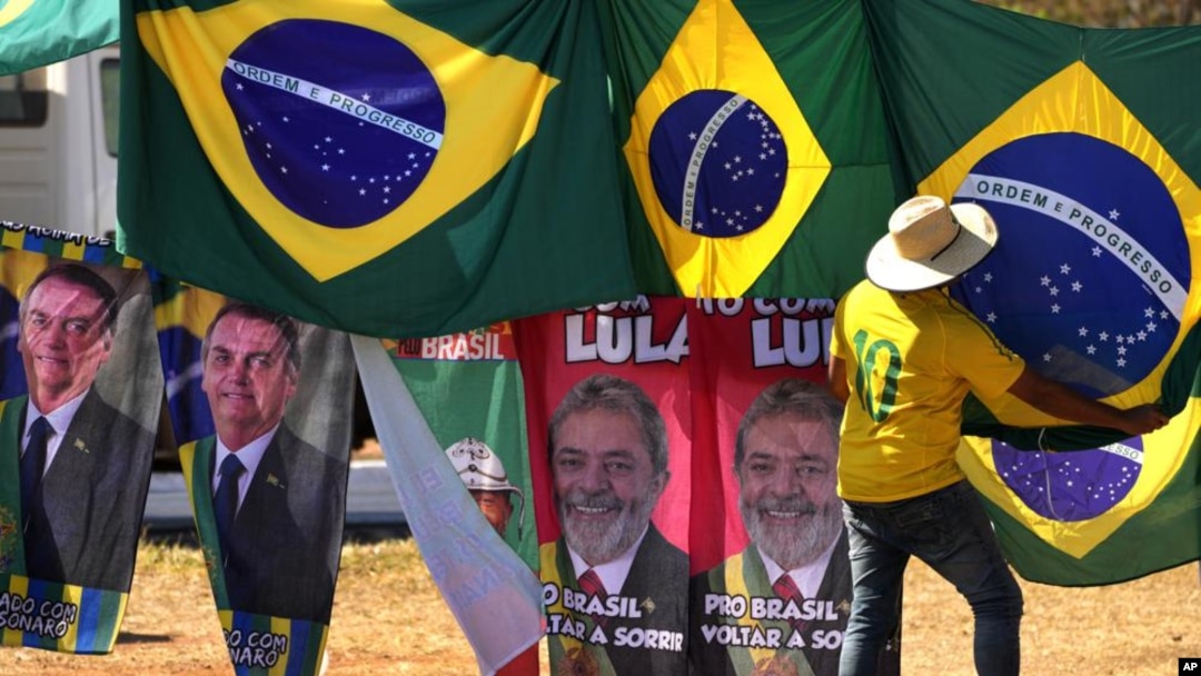 ARCHIVO - Retratos del presidente Jair Bolsonaro, a la izquierda, y del exmandatario Luiz Inácio Lula da Silva, al centro, cuelgan en el exterior de al Corte Suprema Electoral en Brasilia, el 5 de septiembre de 2022. 