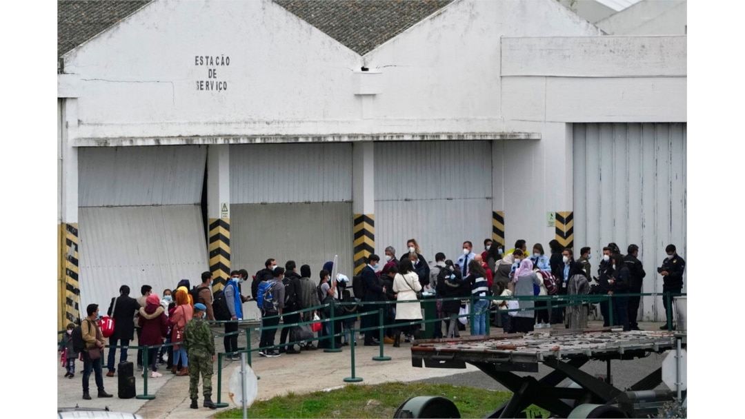 Portuguese border police officers check the documents of Afghan passengers who disembarked from an airplane at Lisbon military airport, Dec. 13, 2021.