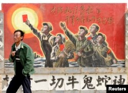 資料照：一名男子走過寧夏銀川街頭郊區的一處描寫中國文革的宣傳畫。 （2007年4月25日）