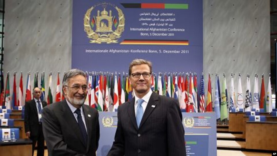 German Foreign Minister Guido Westerwelle, right, and his Afghan counterpart Salmai Rassul shake hands as they visit the World Conference Centre Bonn (WCCB) , Germany, December 3, 2011.