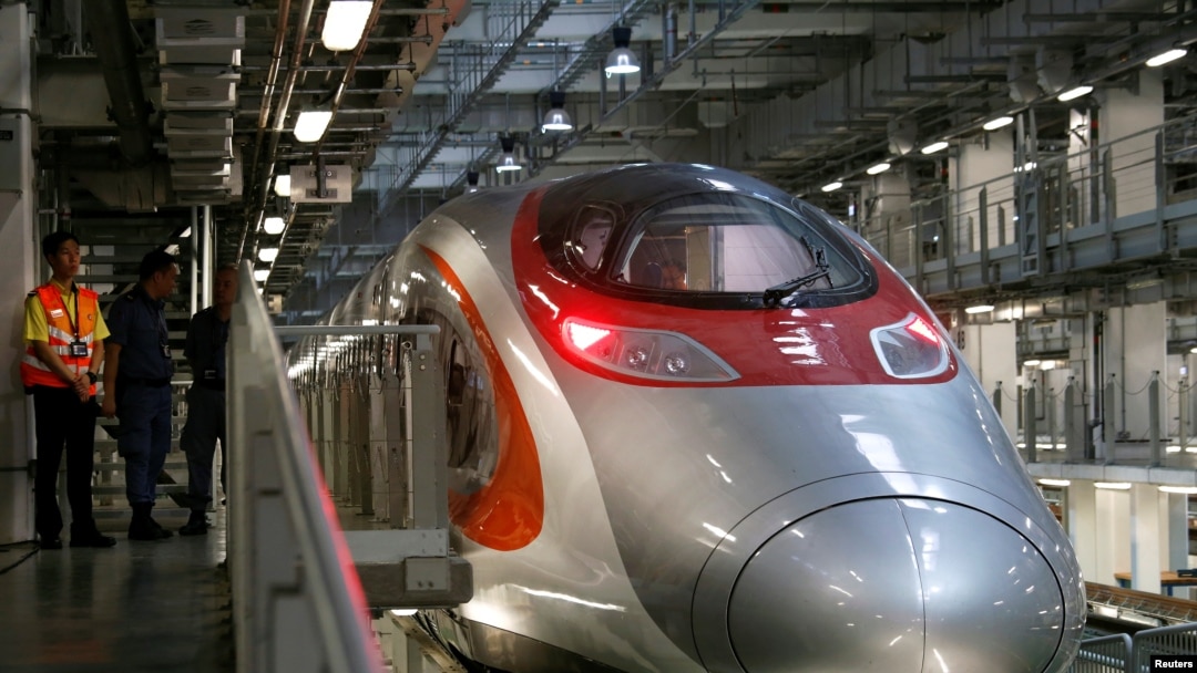 FILE - Crew members chat beside a Guangzhou-Shenzhen-Hong Kong Express Rail train stations at a depot in Hong Kong, China August 16, 2018.