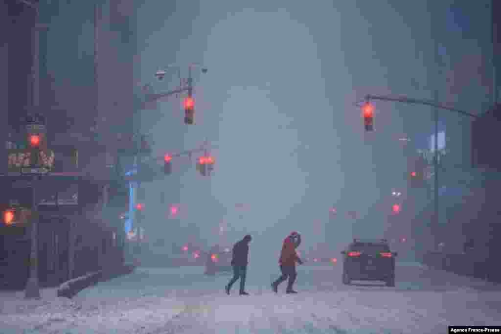 Pedestrians and traffic make their way through heavy snow in Times Square, New York, Jan. 29, 2022. A powerful winter storm packing heavy snow and high winds pummeled the U.S. East Coast, forcing the cancellation of thousands of flights as severe weather alerts were sounded across a region of around 70 million people.