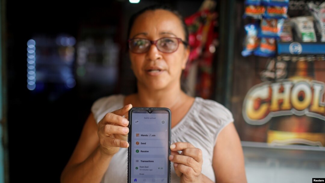 Roxana Valles muestra su teléfono mientras usa la aplicación Bitcoin Beach en su tienda en El Zonte Beach, Chiltiupán, El Salvador, el 10 de junio de 2021. 