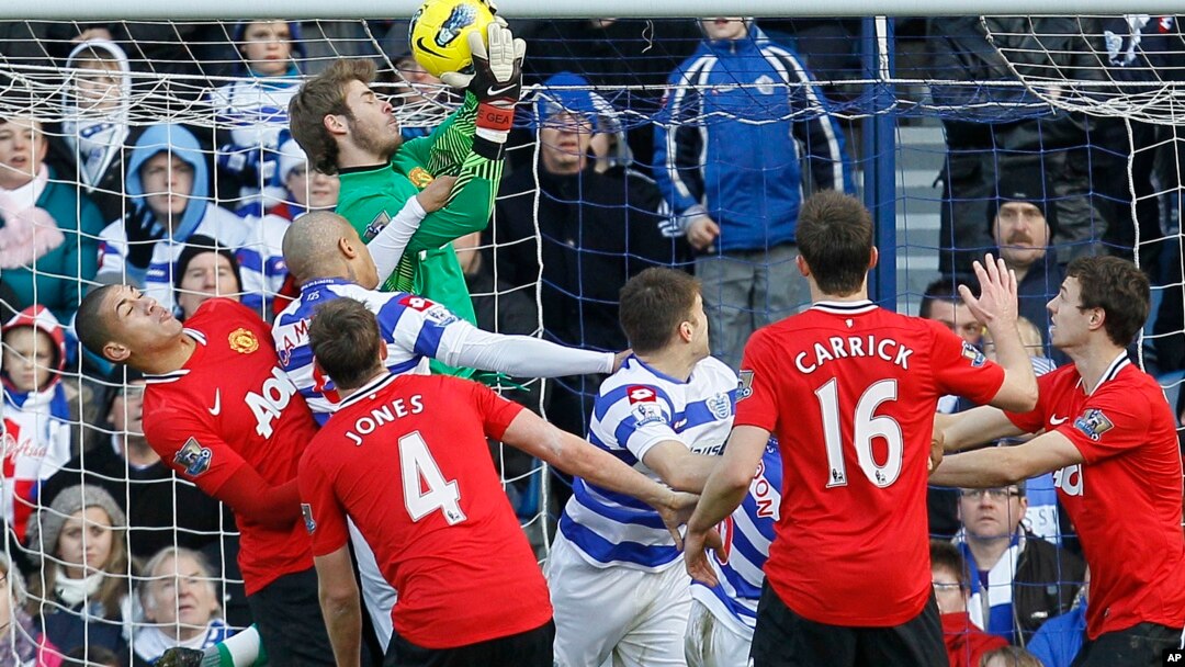 Manchester United's goalkeeper David De Gea catches the ball under pressure from Queens Park Rangers Dudley Campbell, below, during their English Premier League soccer match at Loftus Road stadium in London, Sunday, Dec. 18, 2011. (AP Photo/Alastair Gran