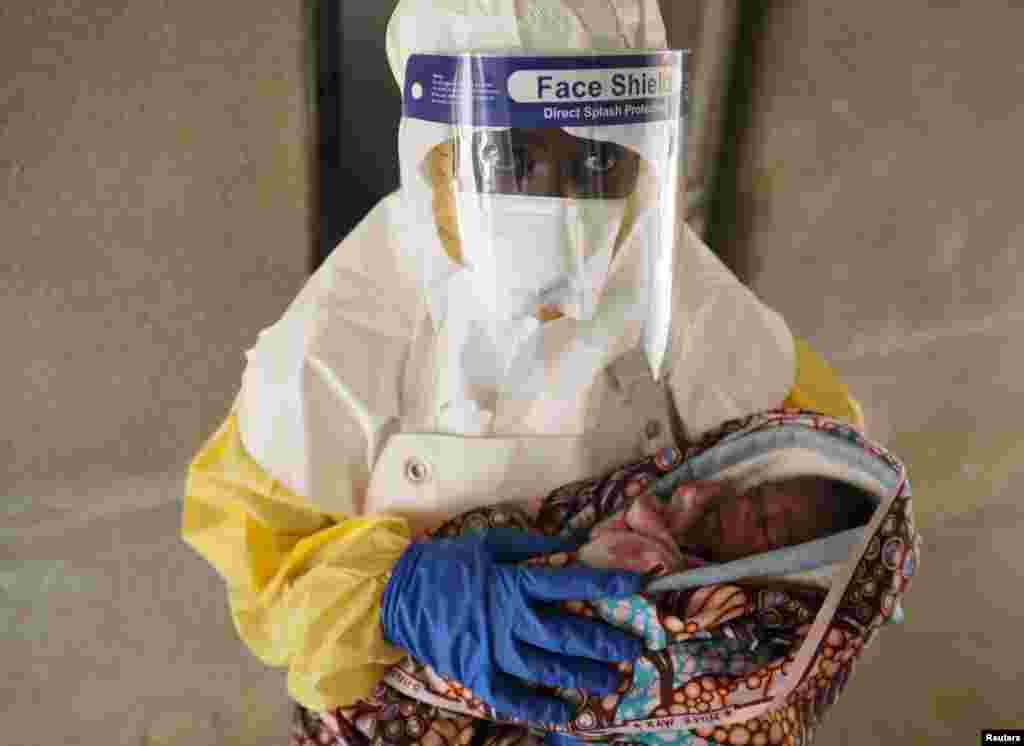 A health care worker carries a baby suspected of being infected with Ebola virus in a hospital in Oicha, North Kivu Province of Democratic Republic of Congo.