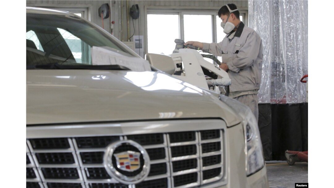 FILE - A staff member works at a service center for repairing Cadillac cars at its dealership in Beijing, China, March 14, 2016.