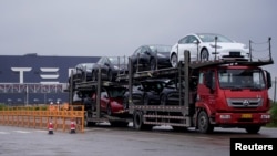 一輛大卡車運出特斯拉上海工廠出產的汽車。 （2021年5月13日）