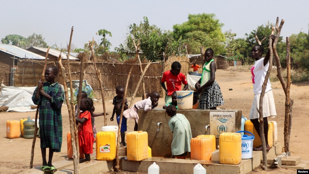 Refugiados sudaneses recolhem água de um furo no campo de refugiados de Gorom. Fotografia de arquivo