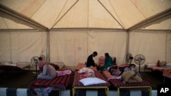 Migrant workers, who left cities and towns where they were abandoned by their employers, rest inside a tent before traveling in special trains arranged to transport them to villages in home states, at a railway station in Gauhati, India, May 28, 2020.