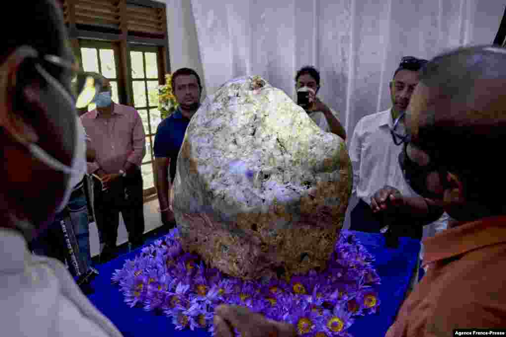People inspect the single natural corundum (blue sapphire) named 'Queen of Asia', considered the largest found in the world, in Horana, some 45 km from Colombo, Sri Lanka.