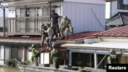Local residents are rescued by Japanese Defense Force soldiers from a flooded area caused by Typhoon Hagibis in Kakuda, Miyagi prefecture, Japan, Oct. 13, 2019, in this photo taken by Kyodo. 
