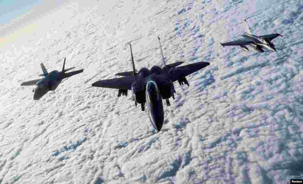 An RAF F-35B Lightning, a USAF F-15E Strike Eagle and a French Rafale fly over The English Channel in formation during the "Point Blank" exercise, after taking off from RAF Mildenhall, Britain, Nov. 27, 2018.