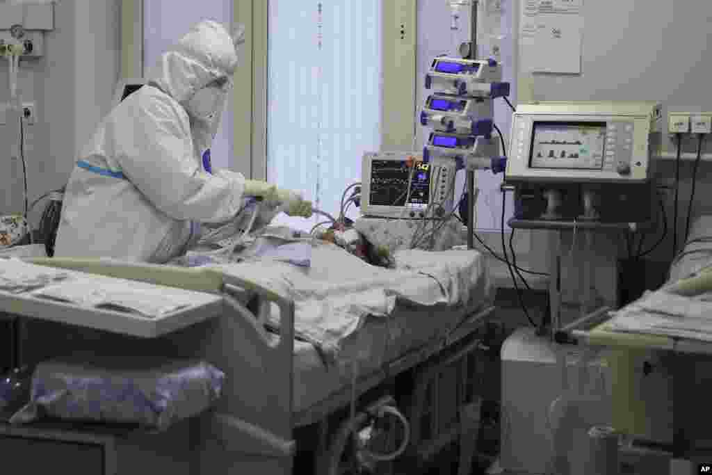 A medical staffer wearing a special suit to protect against COVID-19 treats a patient with coronavirus at an ICU at the Regional Clinical Hospital 1, in Krasnodar, south Russia.