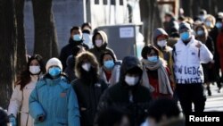 身穿厚保暖外衣的人群走過北京南鑼鼓巷。 （2021年1月16日） 