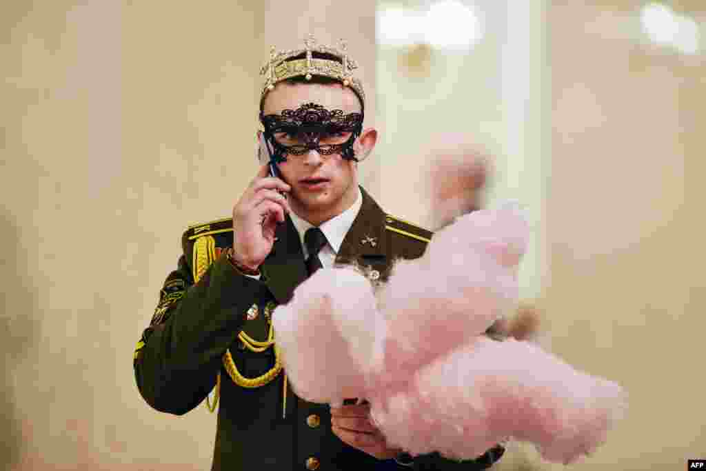 A military cadet holds cotton candy while on his mobile phone during the Big New Year Ball at the Bolshoi Opera and Ballet Theatre in Minsk, Belarus, Jan. 13, 2019.
