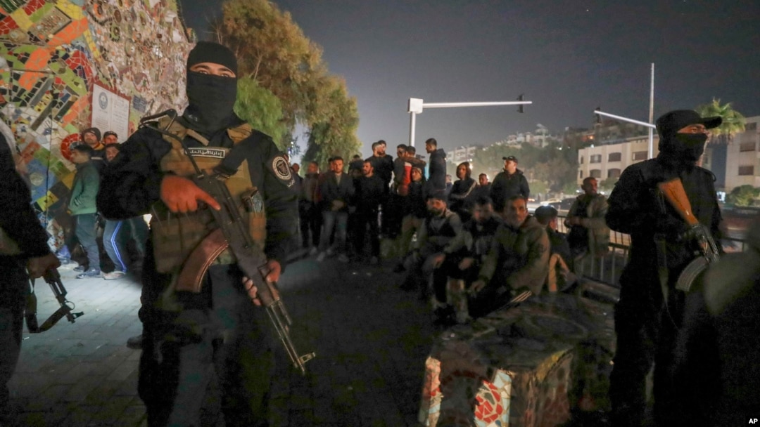 Security forces of the new Syrian government secure the area around group of Alawite protesters in the Mazzeh district of Damascus on Dec. 25, 2024. The minority Alawite community is an offshoot of Shiite Islam to which former President Bashar al-Assad belongs.
