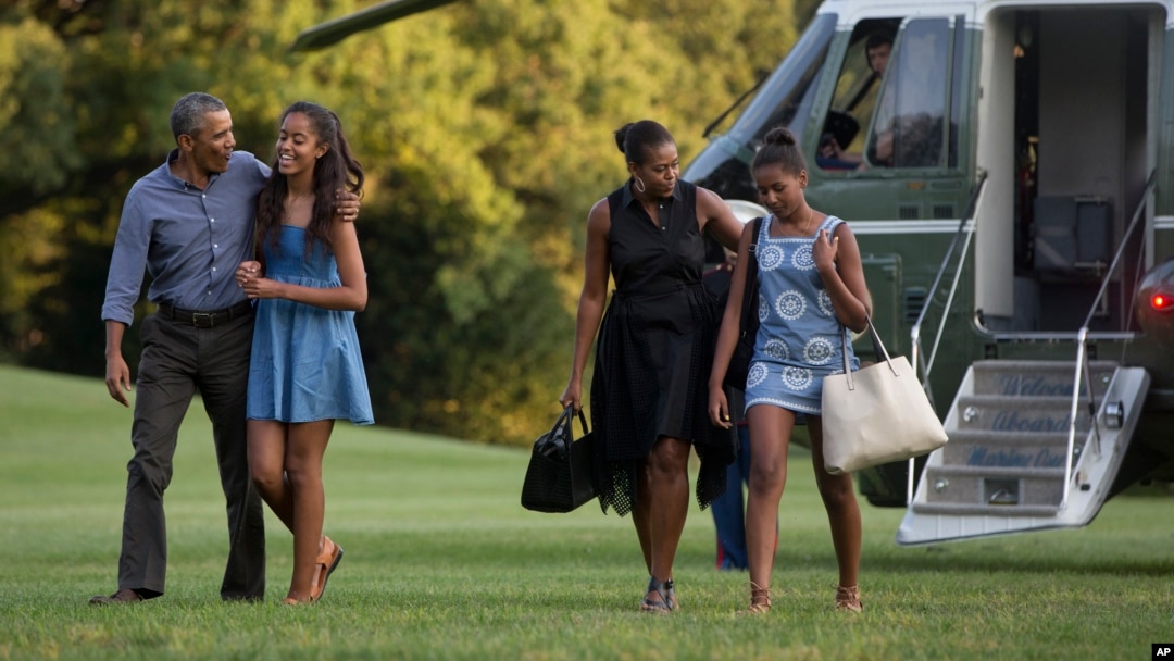 From left, President Barack Obama with daughter Malia and first lady Michelle Obama with daughter Sasha, walk form Marine One across the South Lawn of the White House in Washington, Sunday, Aug. 23, 2015.