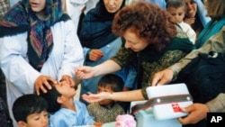 FILE - Ellyn Ogden, USAID's worldwide polio eradication coordinator, immunizes a child during a festive kick-off event for a polio vaccination campaign in Kabul, Afghanistan.