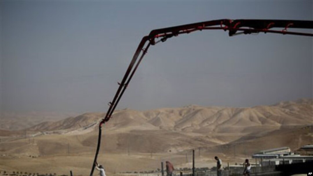 Palestinian men work on a construction site in the West Bank Jewish settlement of Maale Adumim, near Jerusalem, 14 Nov 2010