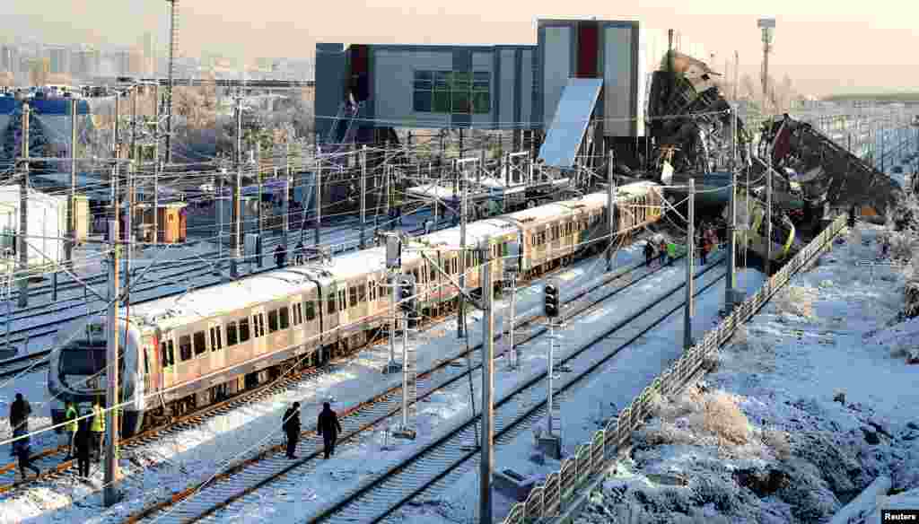 Rescue workers search at the wreckage after a high speed train crash in Ankara, Turkey. Nine people were killed and nearly 50 were injured when a high speed train collided with a locomotive and crashed into a station platform and overpass in an Ankara suburb, officials said.