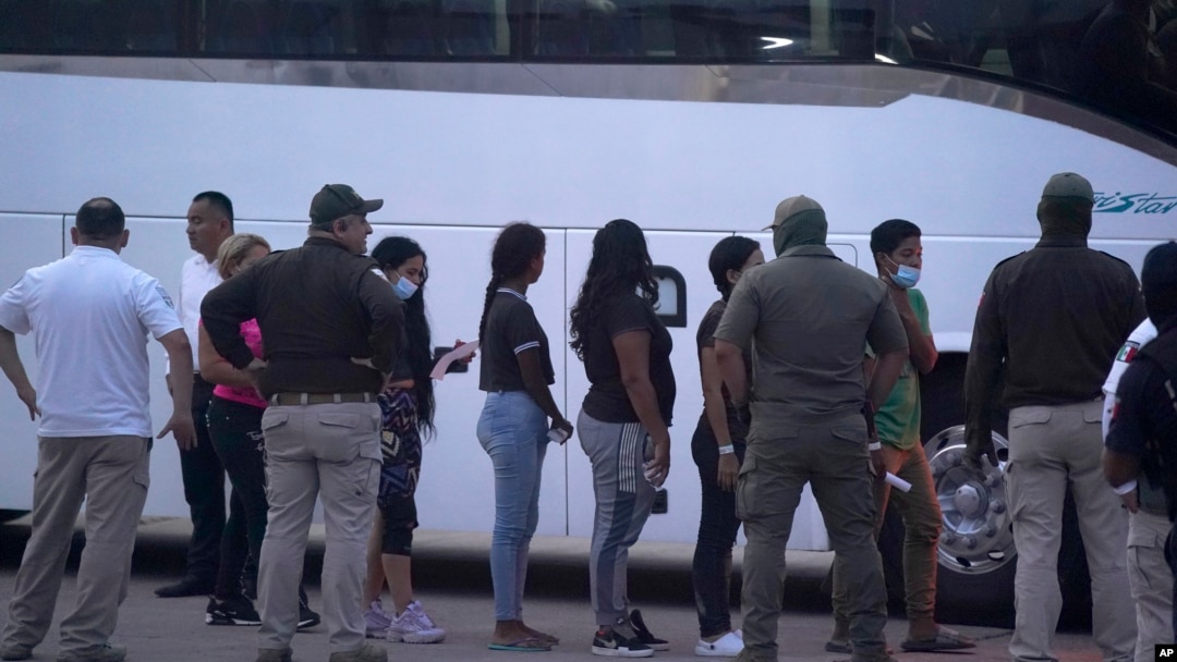 ARCHIVO - Varios migrantes hacen fila para abordar un bus después de ser deportados de Estados Unidos, de regreso a Matamoros, México, el 11 de mayo de 2023.