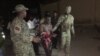 Somali security forces escort a man who was rescued from Pizza House. Somali security forces ended an al-Shabab siege of two Mogadishu restaurants early Thursday morning. About two dozen people were killed.