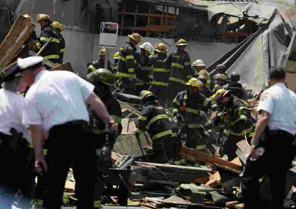 Rescue personnel search the scene of a building collapse in Philadelphia, Pennsylvania, June 5, 2013.