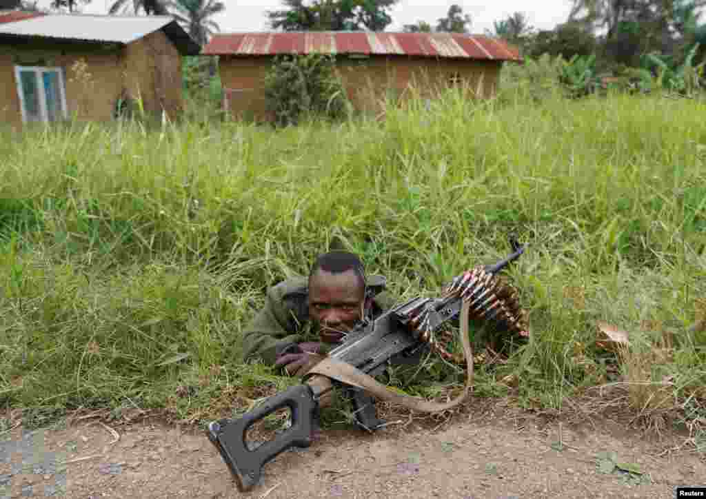 A soldier for the Armed Forces of the Democratic Republic of the Congo (FARDC) rests next to a road after the Islamist rebel group called the Allied Democratic Forces (ADF) attacked the area around Mukoko village, North Kivu province, Dec. 11, 2018.