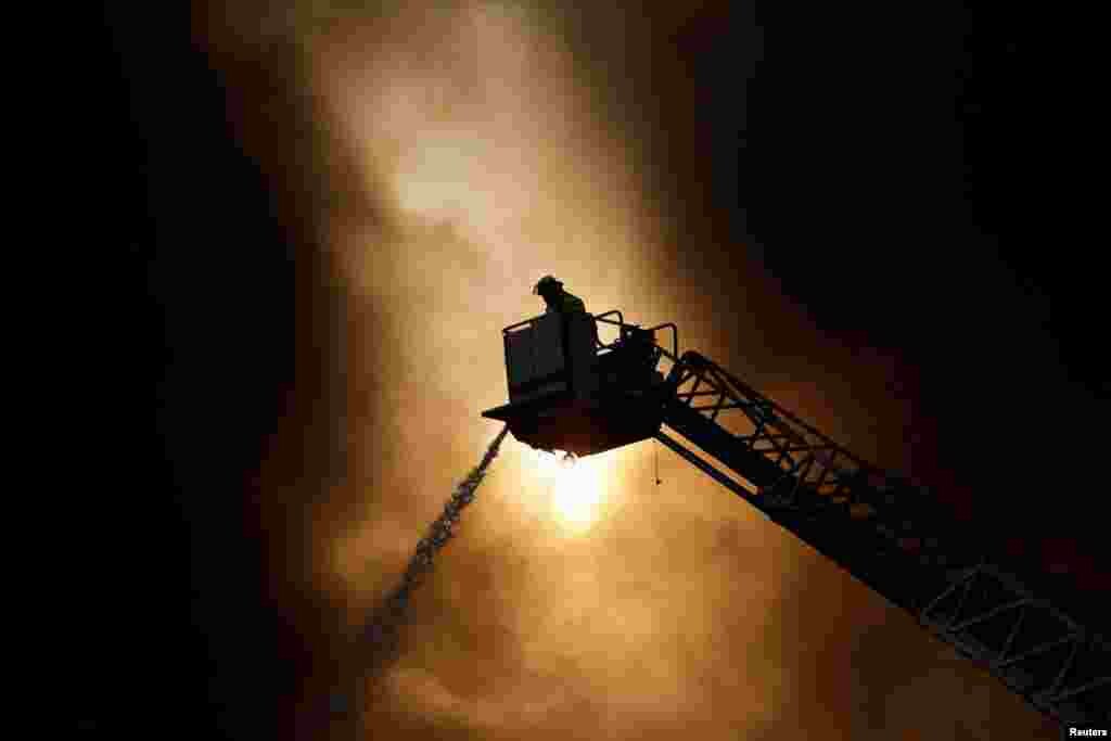 A firefighter extinguishes a fire at a factory at the industrial park "FINSA II" in Santa Catarina, on the outskirts of Monterrey, Mexico, Dec. 13, 2021.