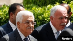 Palestinian President Mahmoud Abbas and his foreign minister Riyad al-Maliki (R) arrive for an Arab League Foreign Ministers emergency meeting at the league's headquarters in Cairo, Sept. 7, 2014.