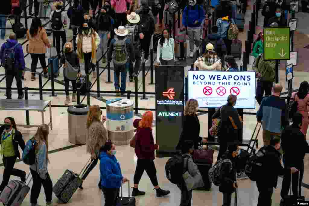 Travelers form lines outside the TSA security checkpoint during the holiday season as the coronavirus Omicron variant threatens to increase case numbers at Hartsfield-Jackson Atlanta International Airport in Atlanta, Georgia, Dec. 22, 2021.