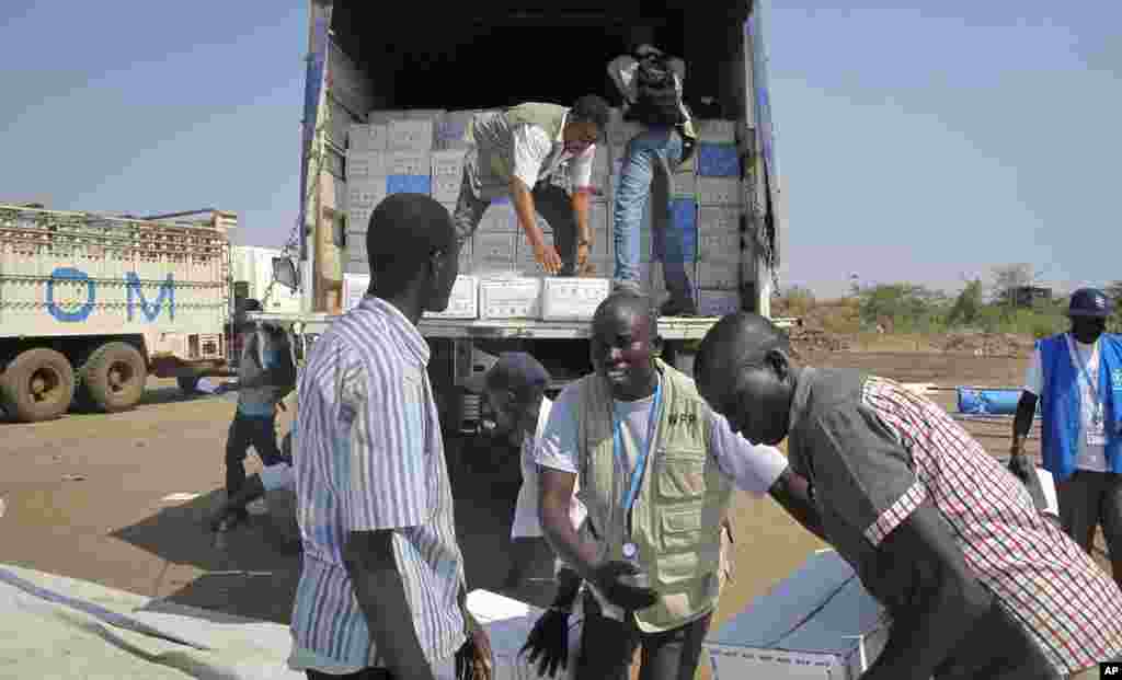 Equipa do Programa Alimentar Mundial descarrega um camião de comida para o campo de refugiados da ONU. Juba, Dez. 24, 2013. (WFP)