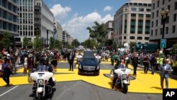 La carroza fúnebre con el ataúd del fallecido legislador demócrata por Georgia, John Lewis, pasa por la Calle 16, de Washington DC, ahora llamada Black Lives Matter Plaza. Julio 27 de 2020.