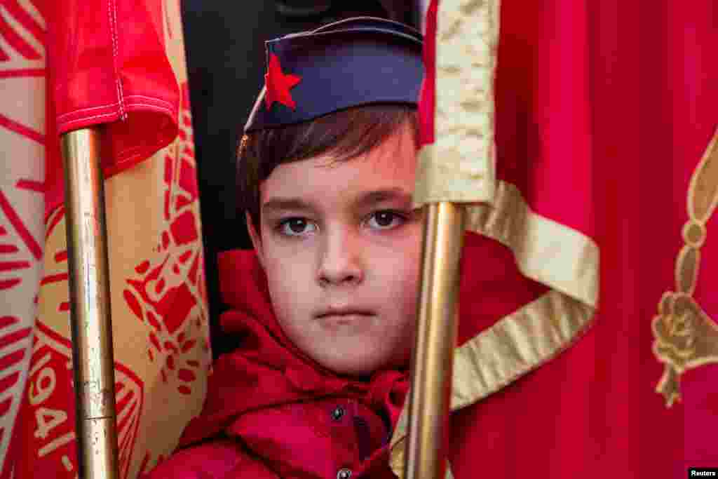 A boy wearing a pioneer hat stands between flag poles during the unveiling ceremony of the monument to the late Yugoslav leader Josip Broz Tito in Podgorica, Montenegro.