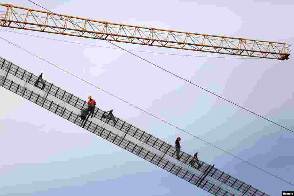 Workers are seen at the construction site of Panggong bridge over the Han river in Xiangyang, Hubei province, China, May 8, 2019.