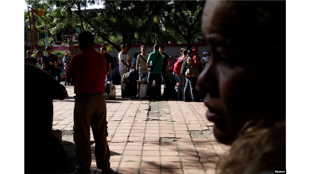 Personas que viajan en autobús desde Caracas a Ecuador hacen fila para sellar sus pasaportes en la oficina de control de migración en San Antonio del Táchira, Venezuela, el 8 de noviembre de 2017.